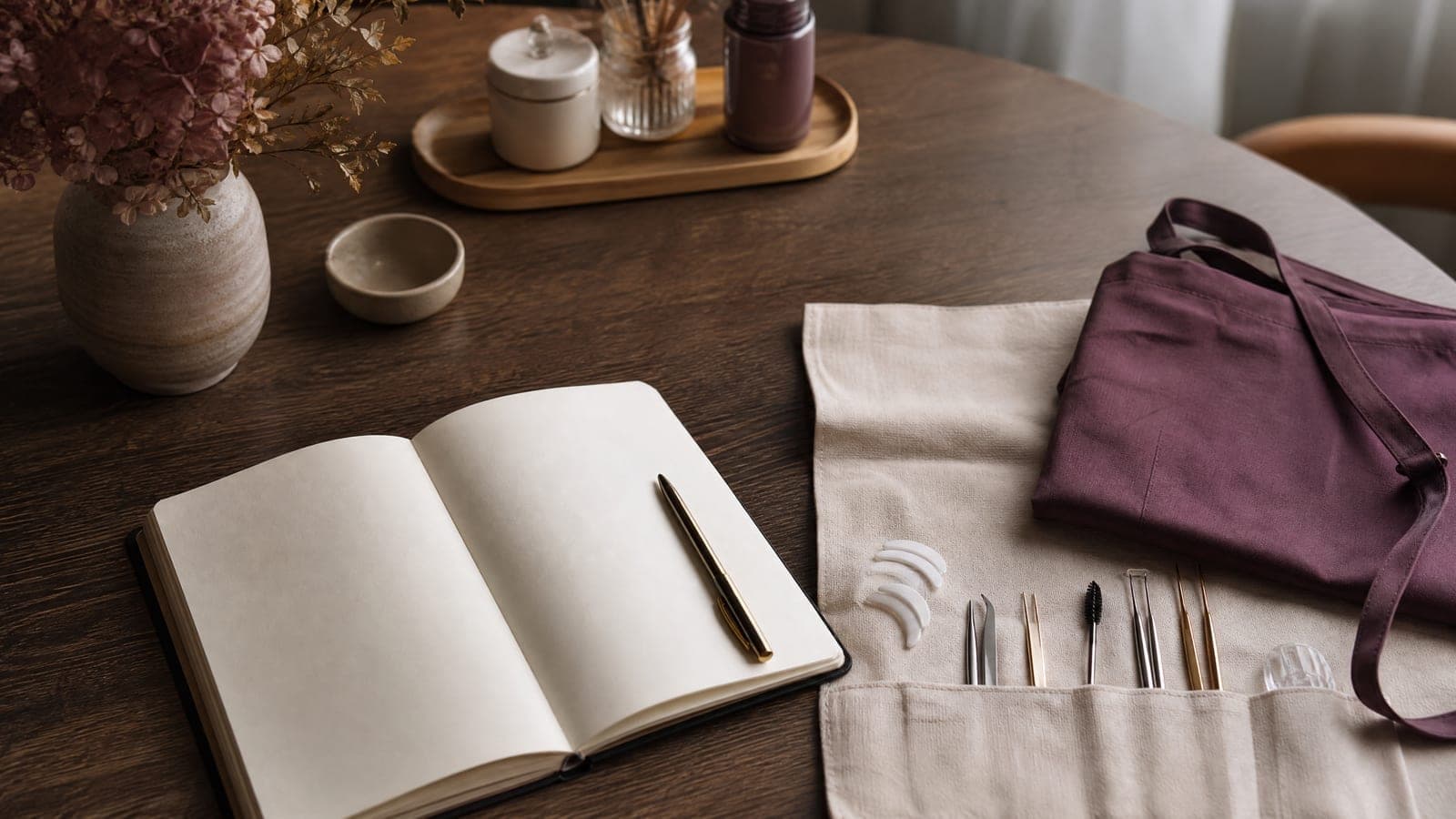 A professional lash and brow training kit laid out on cream linen